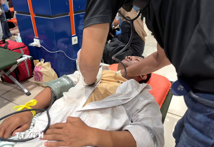 Chăm sóc y tế cho hành khách được giải cứu sau vụ chìm tàu trên biển Java, Indonesia. (Ảnh: THX/TTXVN phát)