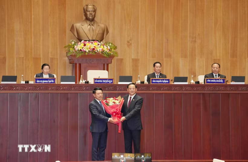 Chủ tịch Quốc hội Lào khóa X Sonexay Siphandone (phải) tặng hoa chúc mừng Thủ tướng Chính phủ Lào khóa X Saleumxay Kommasit. (Ảnh: Xuân Tú/TTXVN)