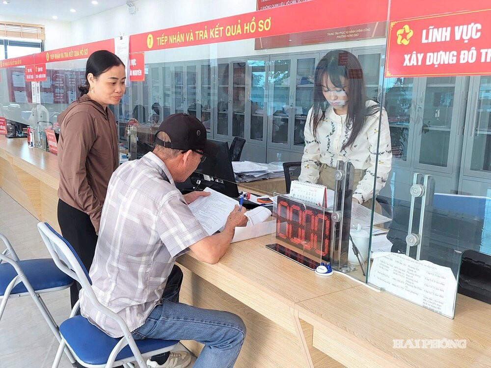 Cán bộ, chuyên viên Trung tâm Phục vụ hành chính công phường Hưng Đạo hướng dẫn người dân làm hoàn thiện thủ tục xin cấp giấy phép kinh doanh.