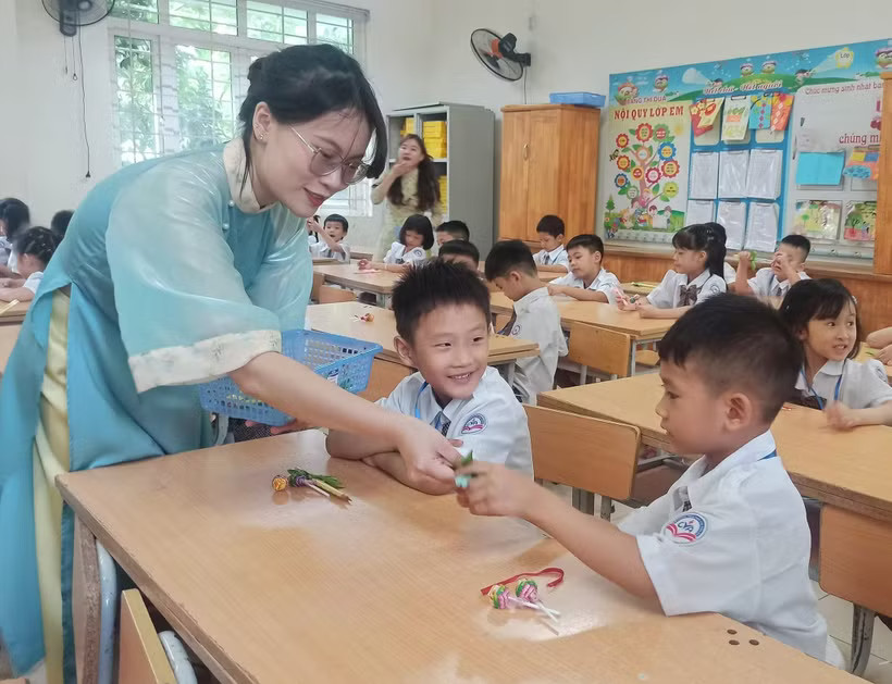Giáo viên chào đón học sinh trong ngày đầu vào lớp 1. (Ảnh: Phạm Mai/Vietnam+)