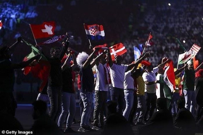  Các tình nguyện viên giơ cao quốc kỳ các nước. (Nguồn: Getty Images) 