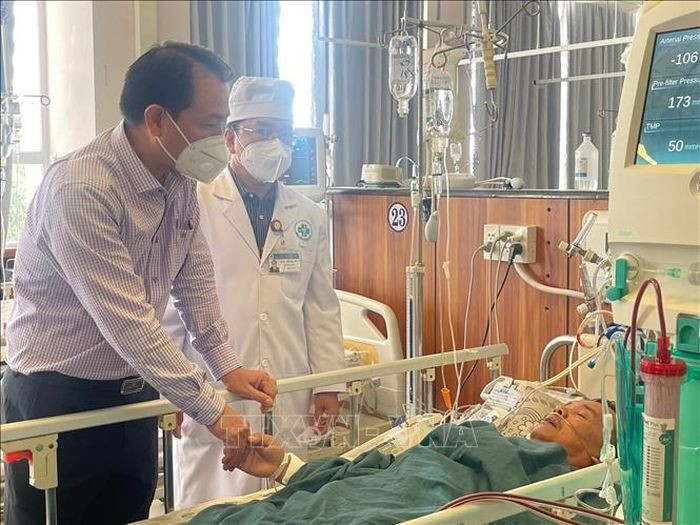 Bác sĩ Trần Quang Hiền, giám đốc Sở Y tế tỉnh An Giang thăm hỏi, động viên trường hợp ngộ độc đang điều trị tại Bệnh viện Đa khoa Trung tâm An Giang. Ảnh minh họa: TTXVN phát