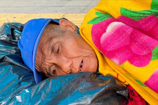 Người đàn ông có biểu hiện tâm thần không bình thường nằm co quắp ở nhà chờ xe buýt