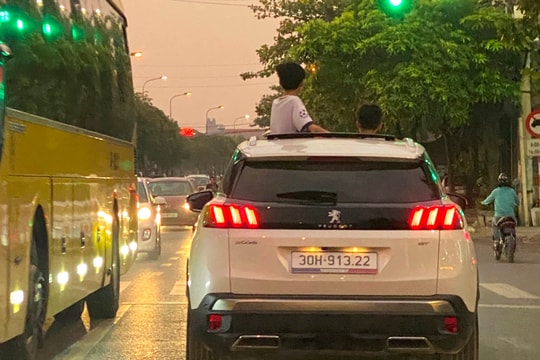 Người lái ô tô để trẻ nhỏ thò đầu qua cửa sổ trời