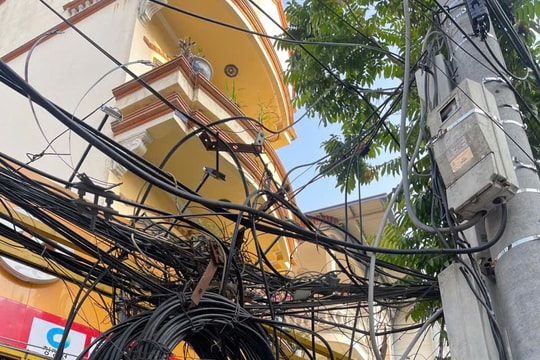 Dây cáp, dây điện chằng chịt trên các cột điện dãy phố Đỗ Nhuận