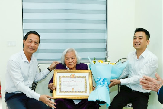 Phó bí thư Thường trực Thành ủy Đỗ Mạnh Hiến trao Huy hiệu 80 năm tuổi Đảng tặng đồng chí Lê Thu ở phường Gia Viên